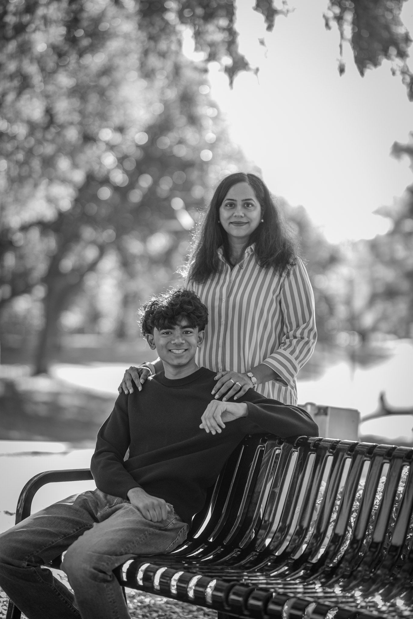 Linearity Founders sitting on a bench in a park with trees in the background
