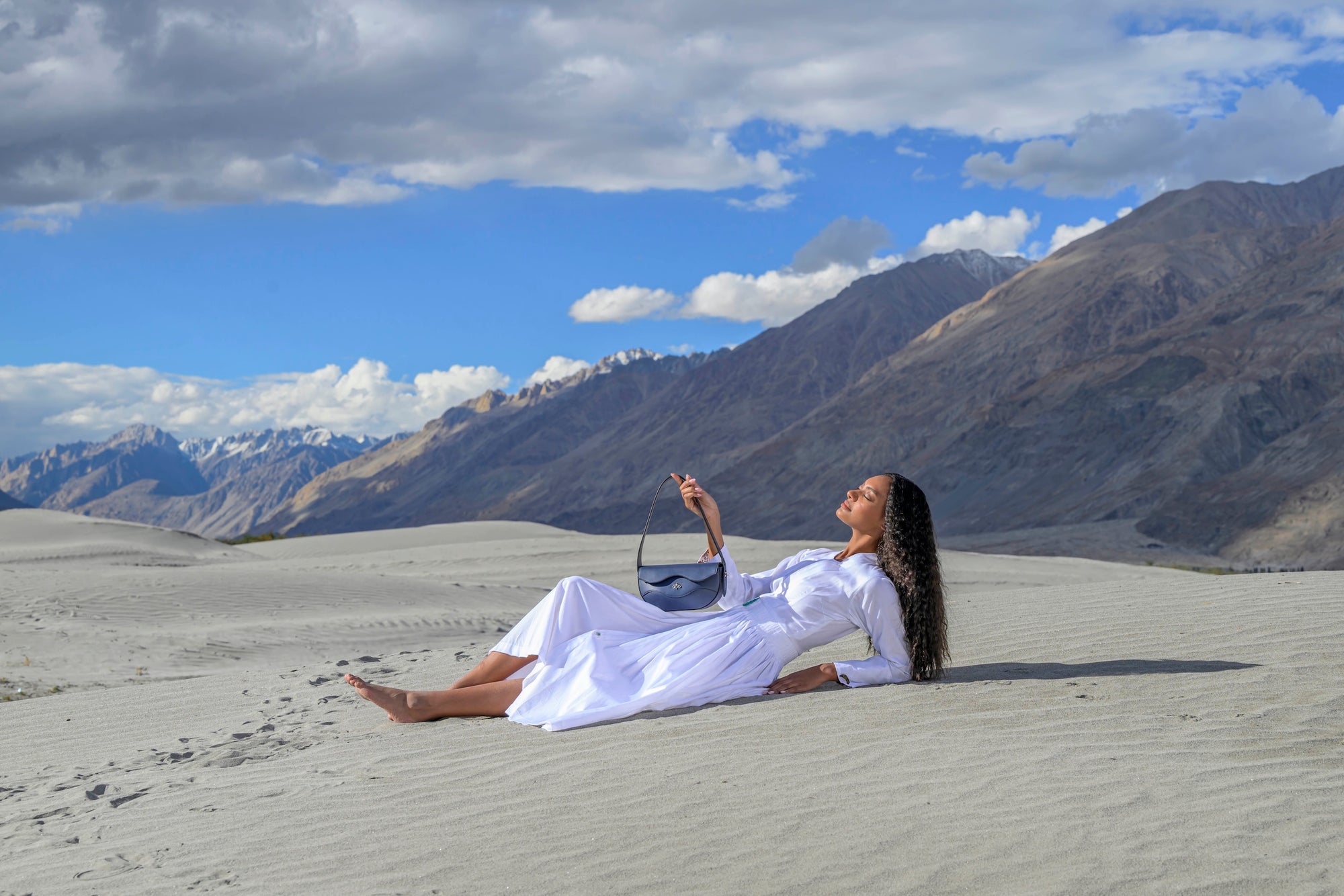 Waves bag held by model in a sandy landscape