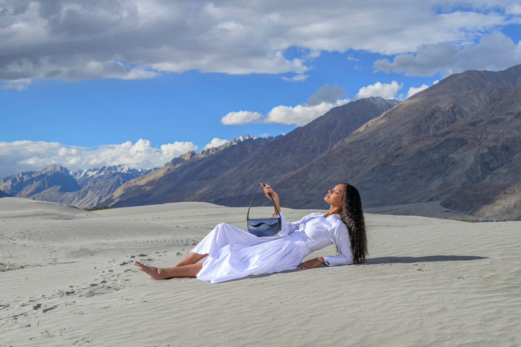 Waves bag held by model in a sandy landscape