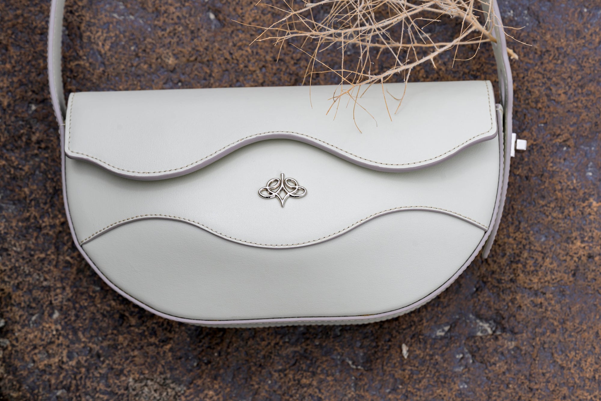 Ascot grey linearity handbag with a decorative clasp on a textured surface