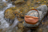 Brown linearity bag on a rock with flowing water in the background